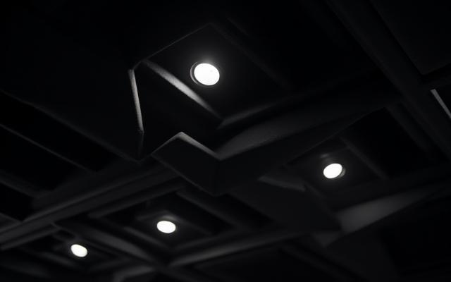 Detalle de la iluminación técnica en el techo de un estudio de grabación con paneles acústicos.